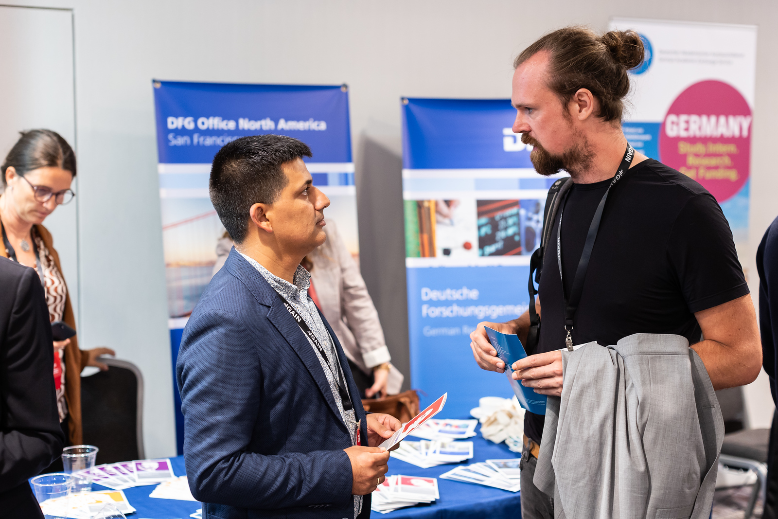 Participants talk in front of the DFG stand