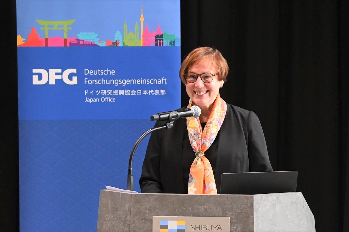 Ingrid Krüßmann stands at the lectern and speaks to the guests. A DFG display stands in the background.