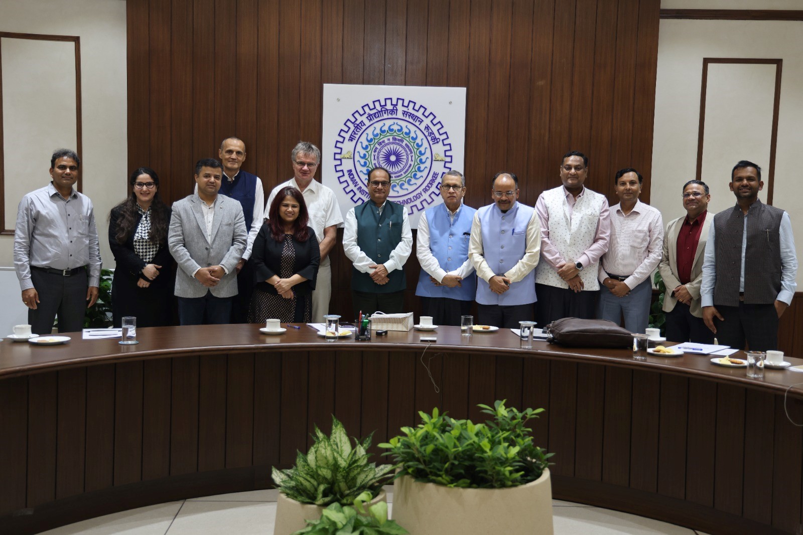 The German delegation with Director IIT Roorkee and Deans stand inside behind a slightly round table.