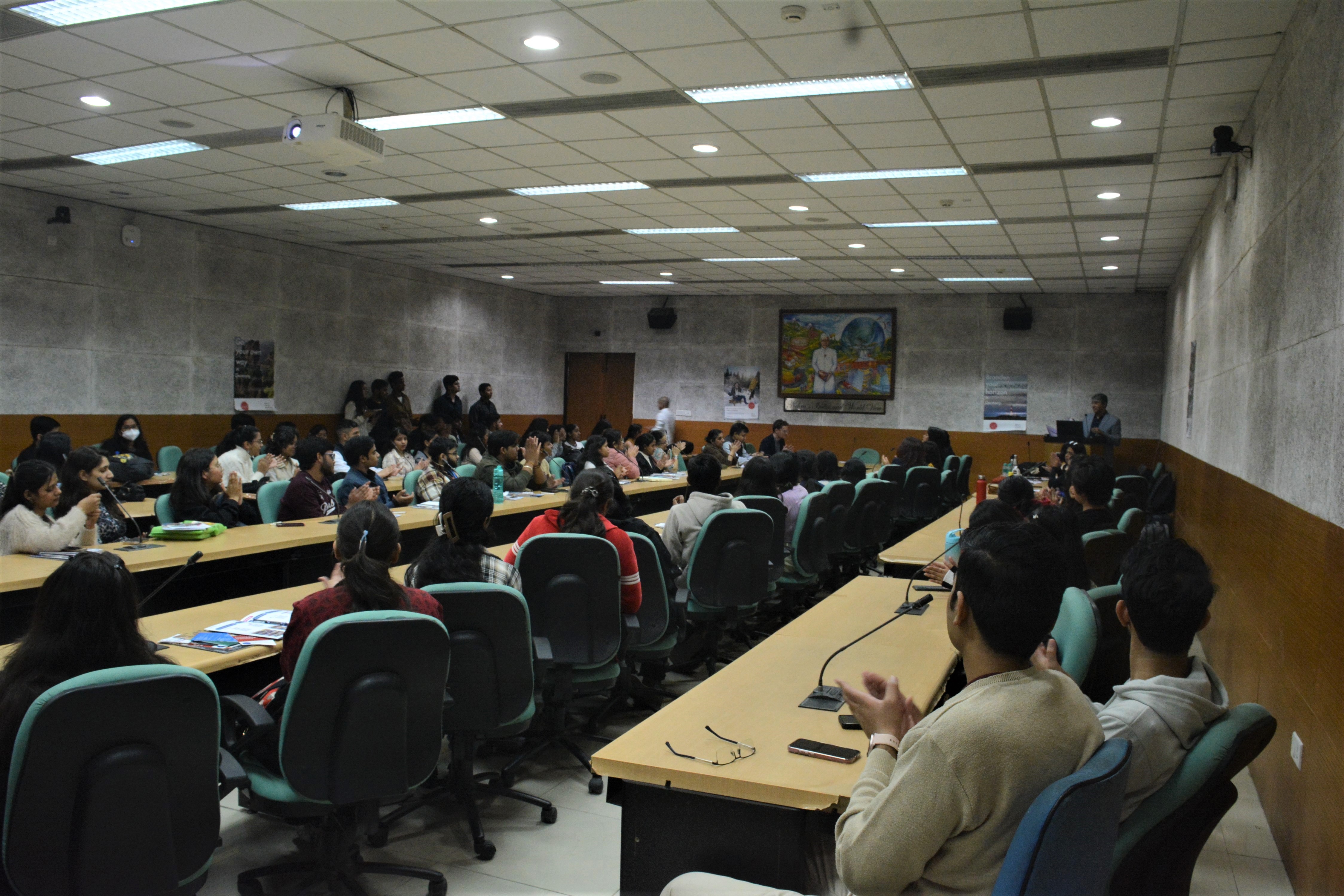 Faculty and students of JNU and neighbouring universities sit in several rows.